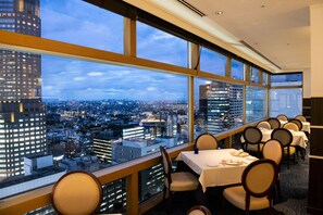 Habitación de hotel en un rascacielos, con amplias ventanas que ofrecen vistas a la ciudad.