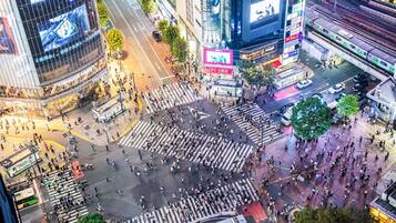 A busy urban intersection with crosswalks and traffic lights.