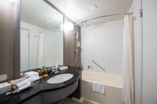 Un baño moderno con un lavamanos grande, espejo, ducha y bañera.