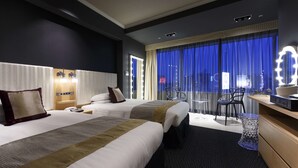 A hotel room with two beds, a desk with a mirror, and a view of the city at night. - Shibuya Excel Hotel Tokyu (Tokyo)