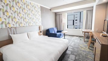 Ein Hotelzimmer mit einem großen Bett, einem Schreibtisch, einem Sessel und einem Sofa.