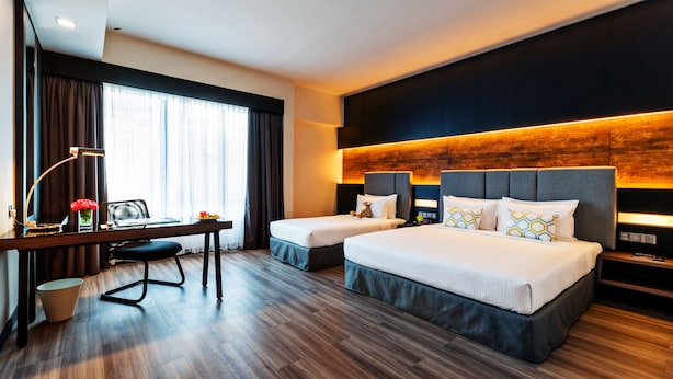 A hotel room with a large bed, a smaller bed, a desk with a lamp, and a view of the outdoors through large windows. - Hotel Armada Petaling Jaya (Petaling Jaya)