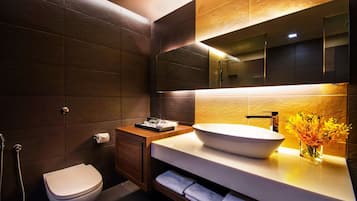 Une salle de bain moderne avec un grand miroir, un lavabo sur colonne et des toilettes.