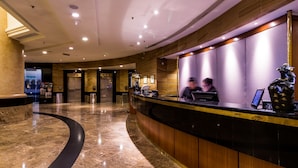 A hotel reception area with a curved reception desk, a marble floor, and a modern interior design. - Hotel Armada Petaling Jaya (Petaling Jaya)