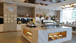 A modern hotel lobby with a marble reception desk, a wall of circular signs, and a buffet area with flowers and food displays. - Hotel Armada Petaling Jaya (Petaling Jaya)