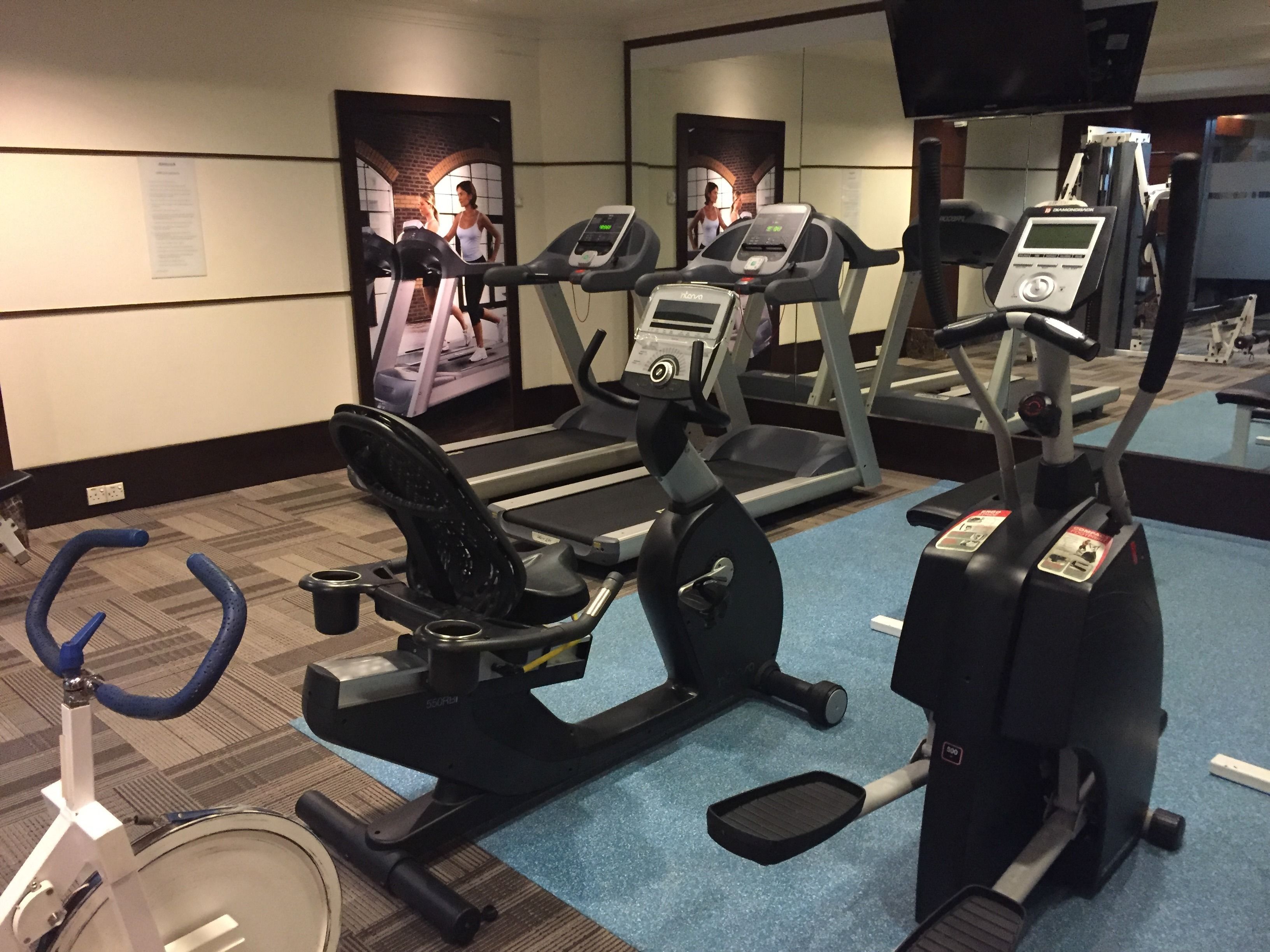 A gym with treadmills, an elliptical, and a stationary bike.