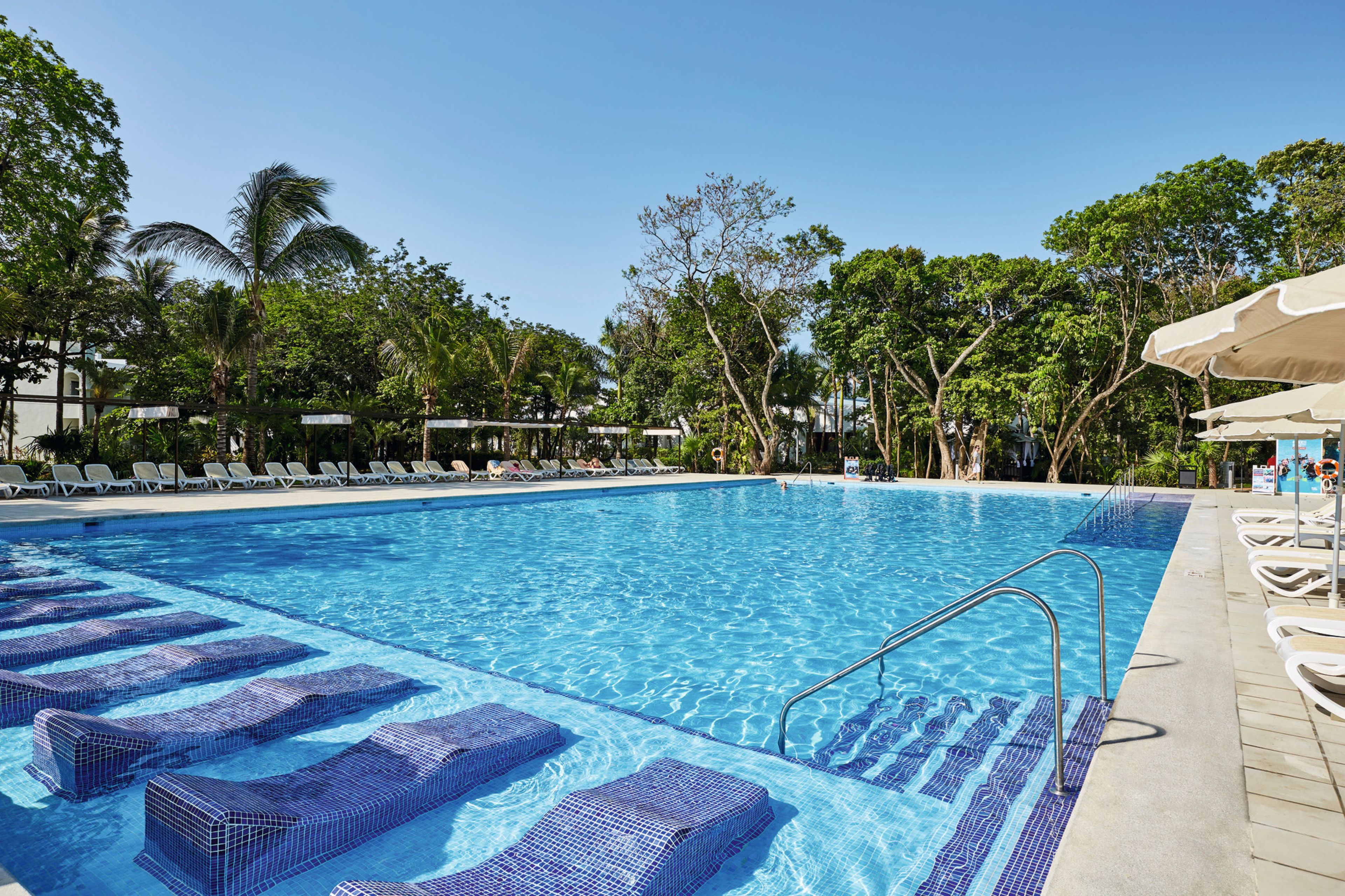 Ein Swimmingpool mit Liegestühlen und blauem Himmel.