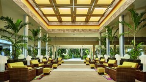 A spacious lobby with wicker furniture, large windows, and a view of the outdoors.