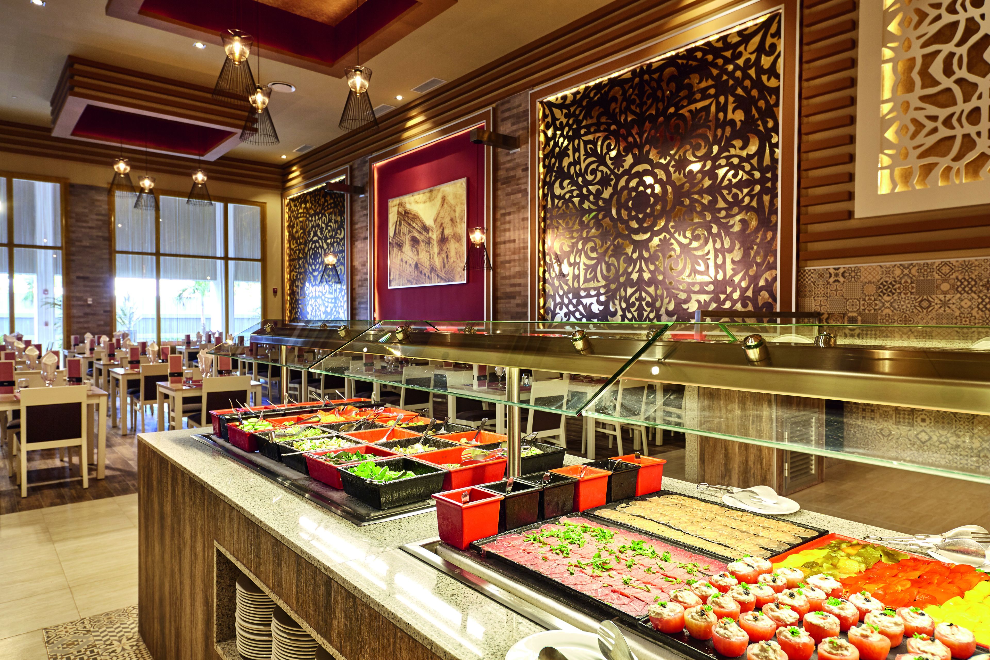 A buffet with various food options, including salads, meats, and appetizers.