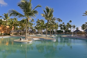 A pool area with palm trees and lounge chairs.