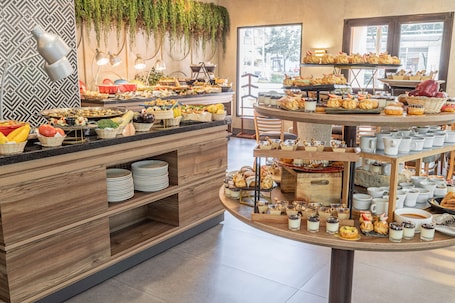 A buffet with various food items and a coffee station.
