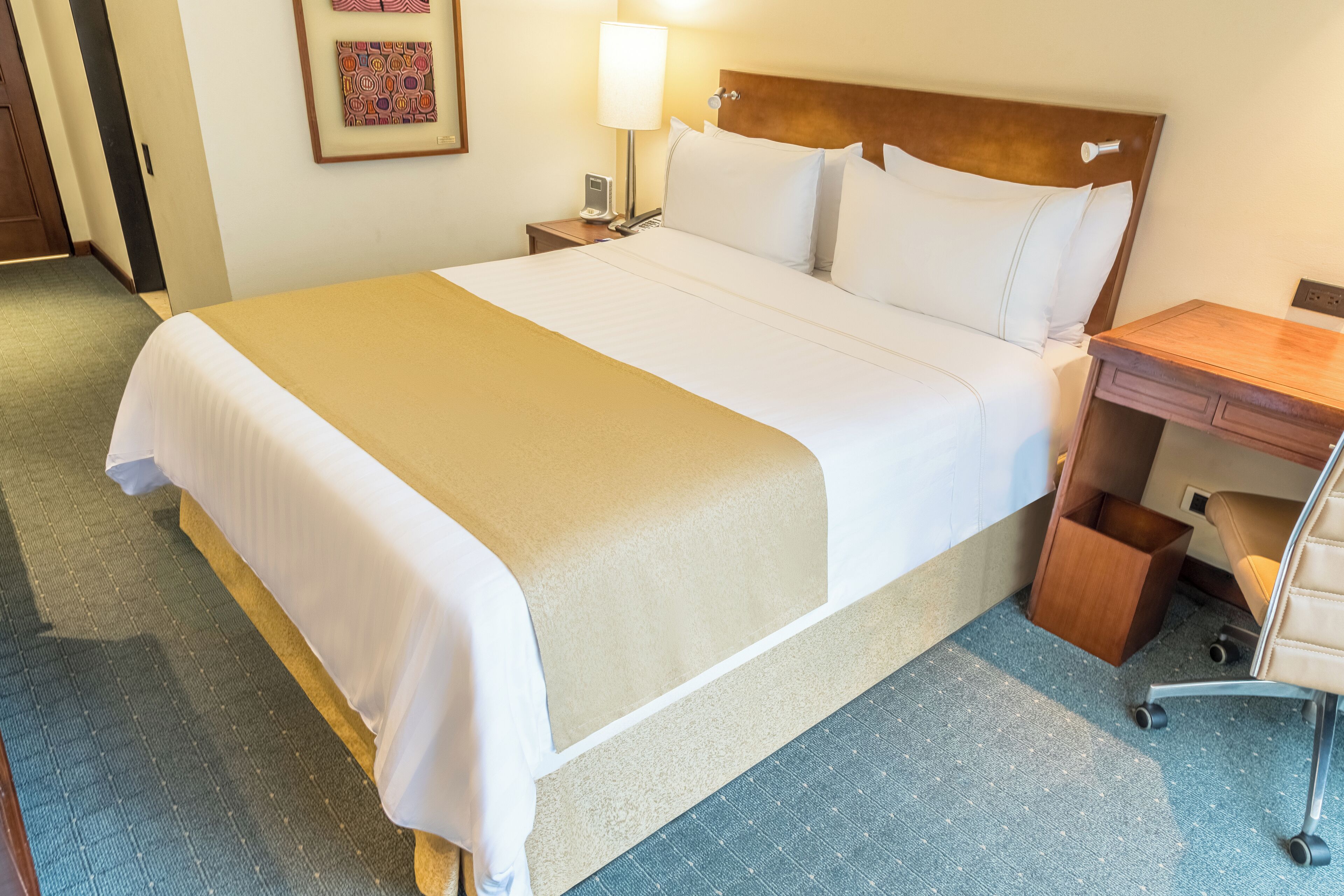 Una habitación de hotel con una cama grande, un escritorio y una silla.