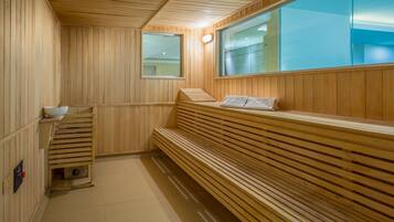 A wooden sauna with benches and a window.