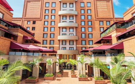A hotel with a central entrance, multiple floors, and a brick facade.