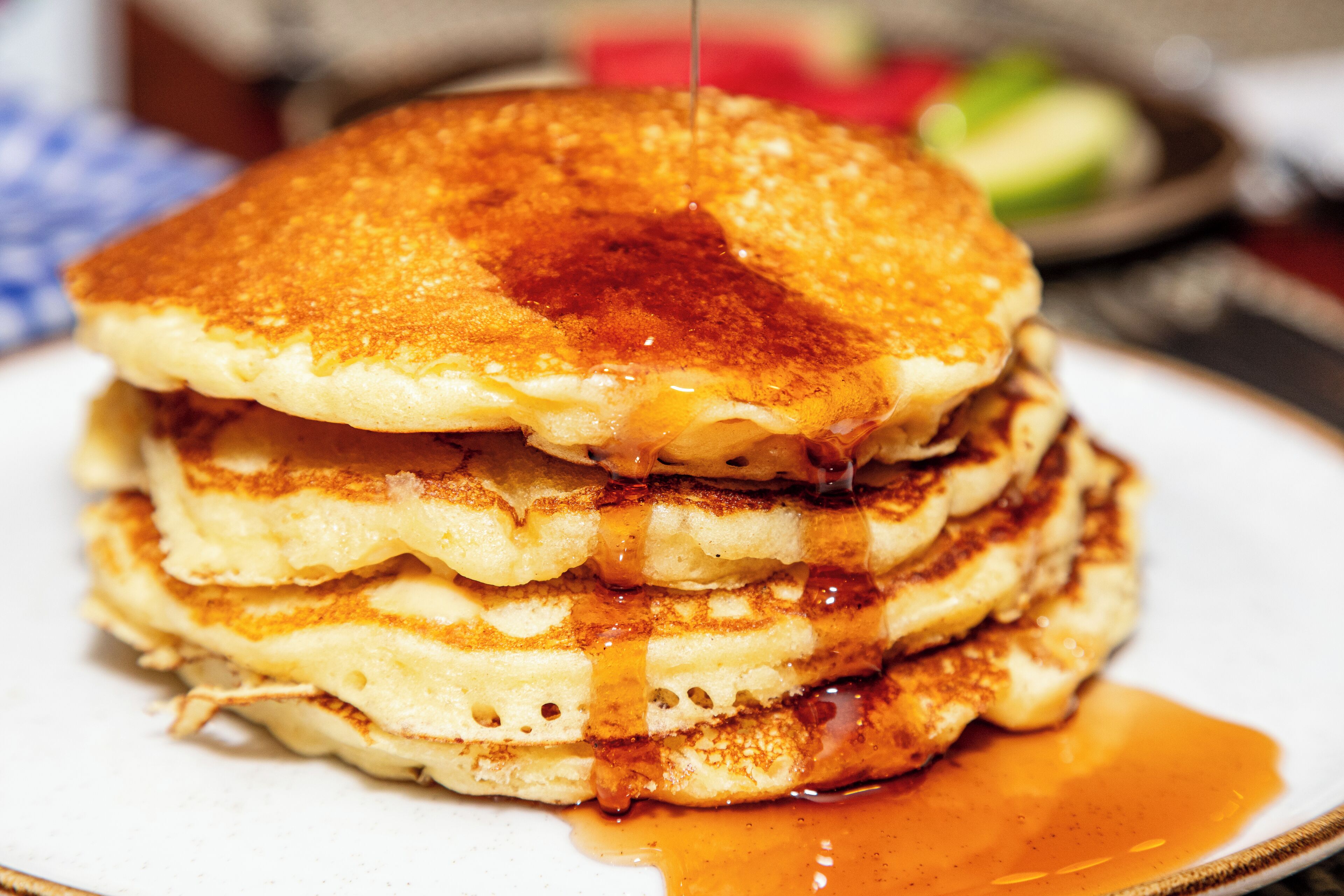 Een stapel pannenkoeken met siroop.