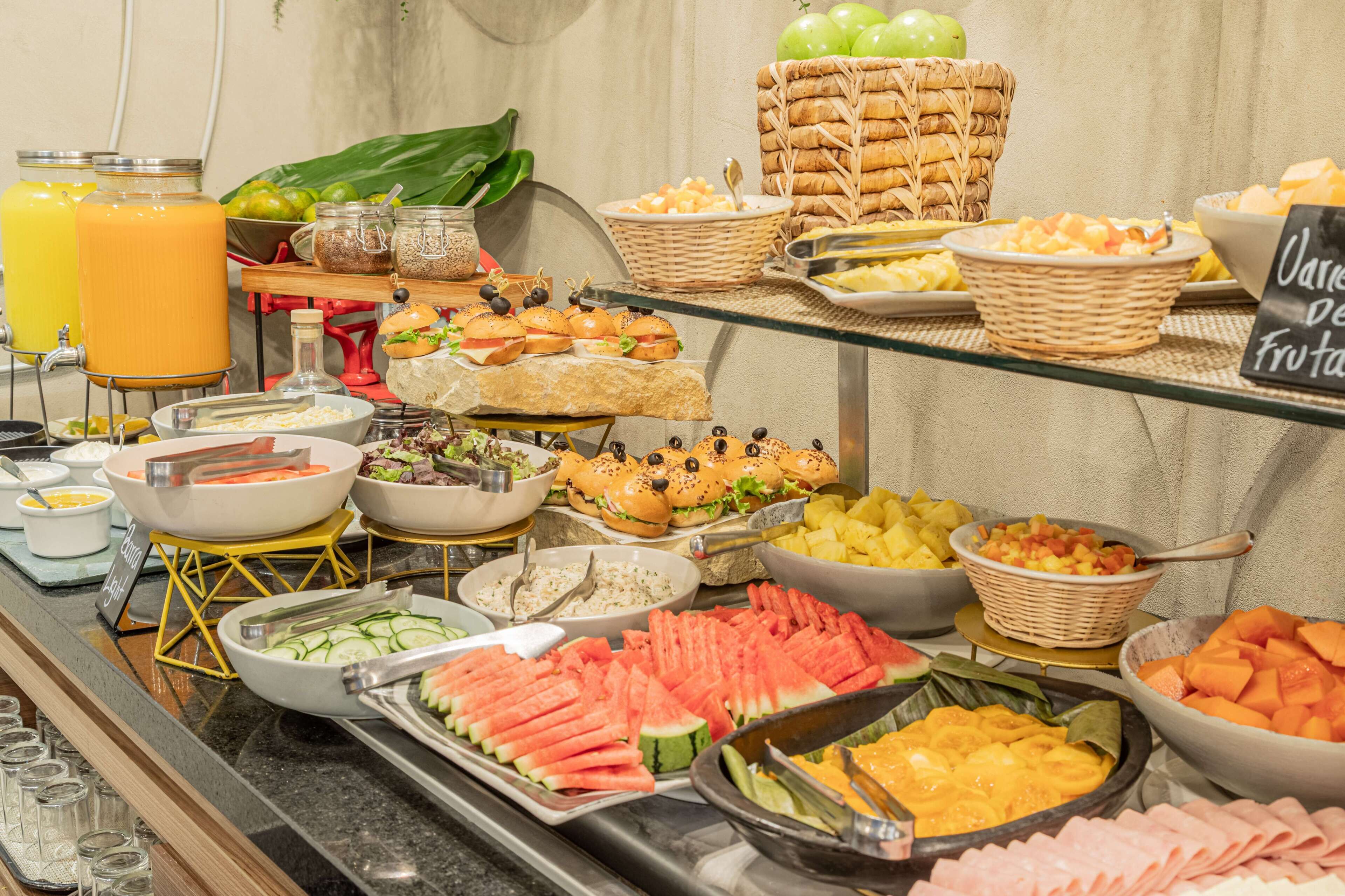 A buffet with various food items and a juice dispenser.