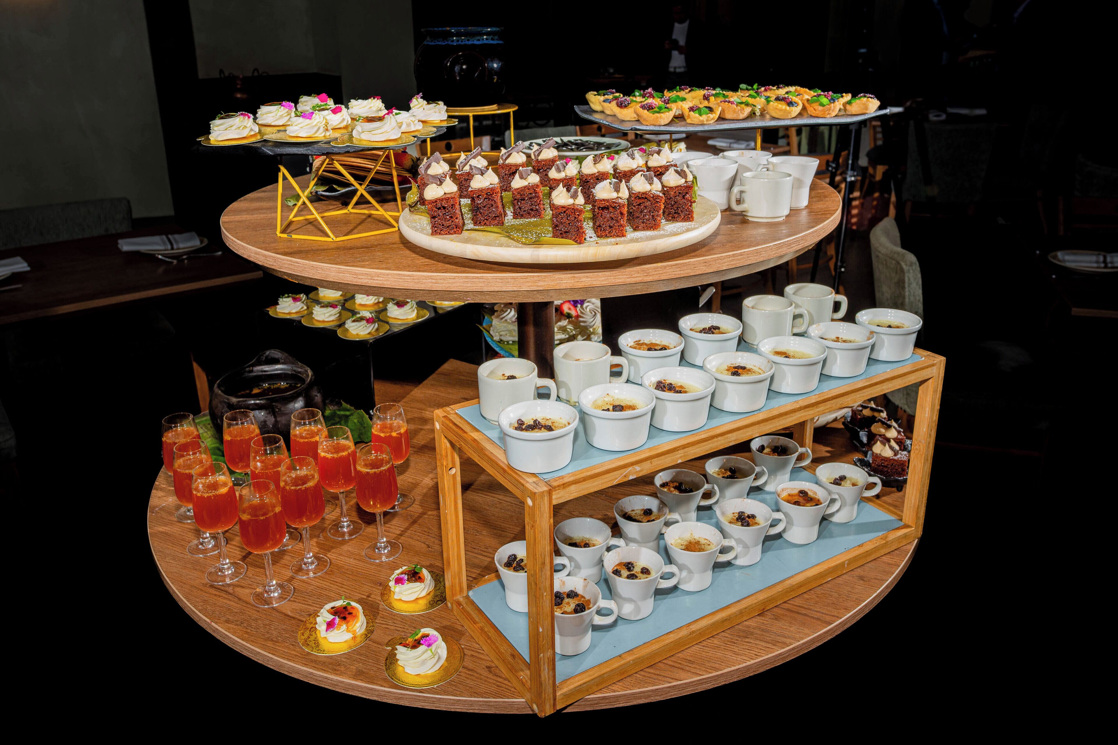 A multi-tiered dessert display with various pastries and beverages.