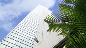 Exterior del Hotel Torre De Cali con un diseño moderno, destacando un cartel y una vista del cielo.