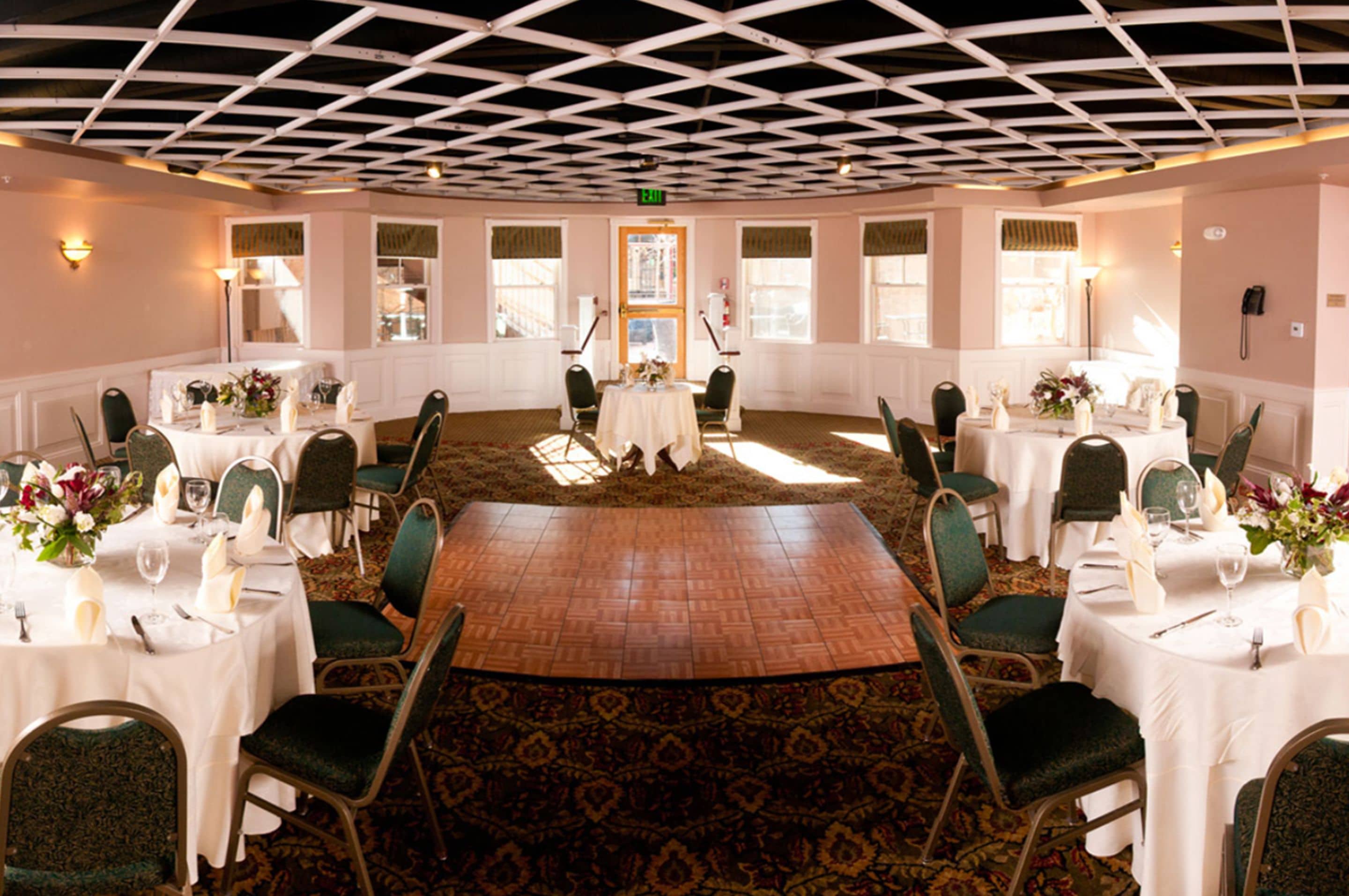 A conference room with a central table, surrounded by chairs, and a patterned carpet.