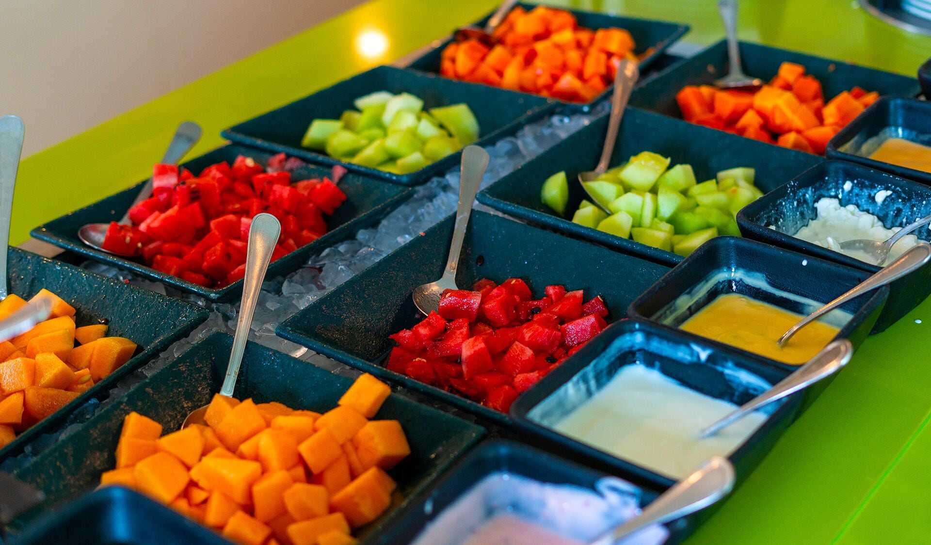 A buffet with various fruits and dips.