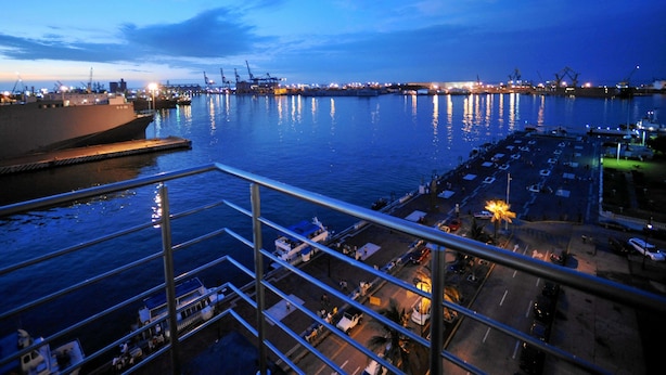 Vista al frente del agua con un puerto deportivo, barcos amarrados y un gran barco llamado 'CROSLEY' al fondo.
