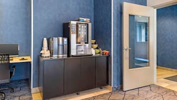 Una kitchenette equipada con cafetera, refrigerador y microondas.