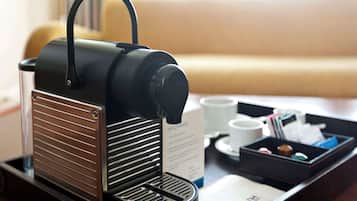Una cafetera sobre una bandeja con un menú y una taza de café.