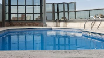 Una piscina al aire libre de temporada, sillones reclinables de piscina