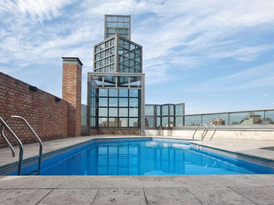 Een seizoensgebonden buitenzwembad, ligstoelen bij het zwembad