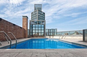 Una piscina al aire libre de temporada, sillones reclinables de piscina