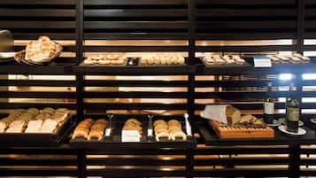 Mostrador de panadería con diversos panes y pasteles.