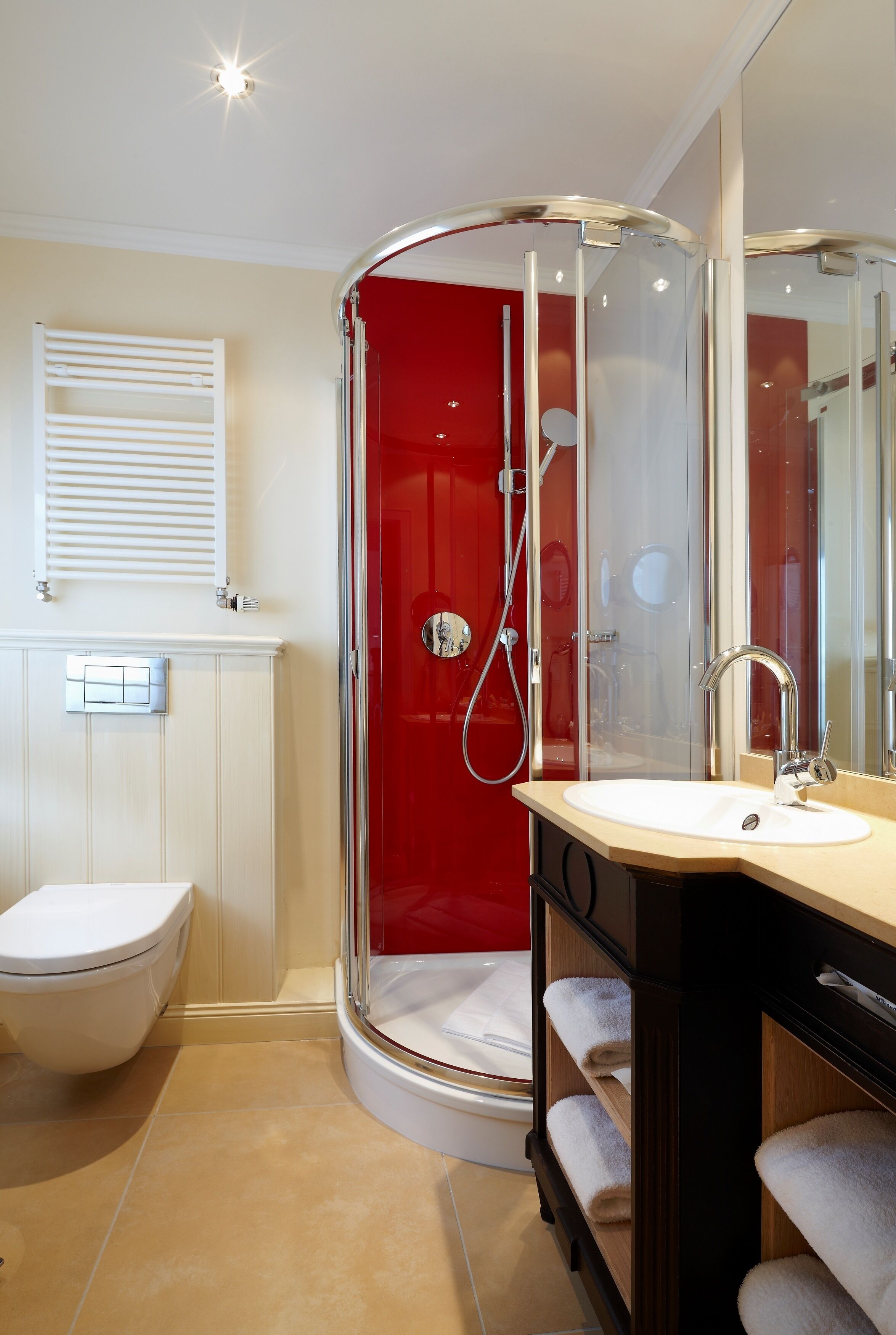 Un baño moderno con ducha envuelta en vidrio, inodoro blanco y tocador con espejo.