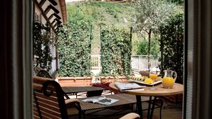 Eine Terrasse mit Tisch und Stühlen, ein Krug Orangensaft und ein Teller Essen.