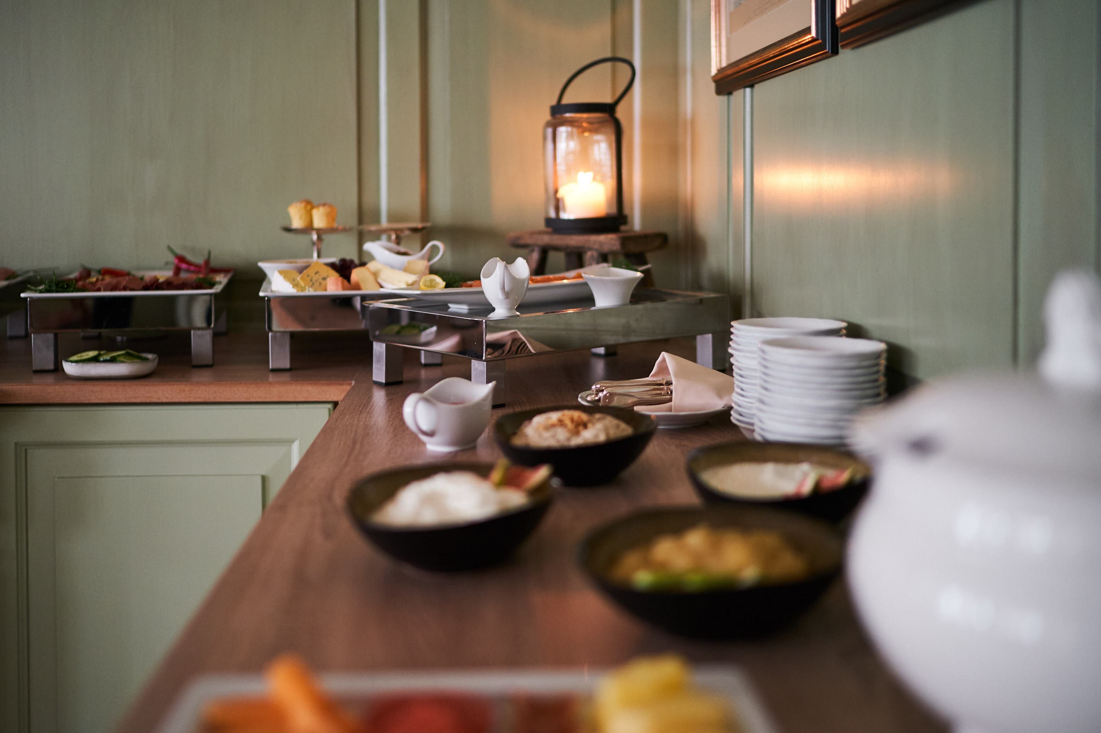 A buffet setup with various dishes and a lantern in the background.