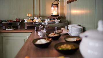 A buffet setup with various dishes and a lantern in the background.