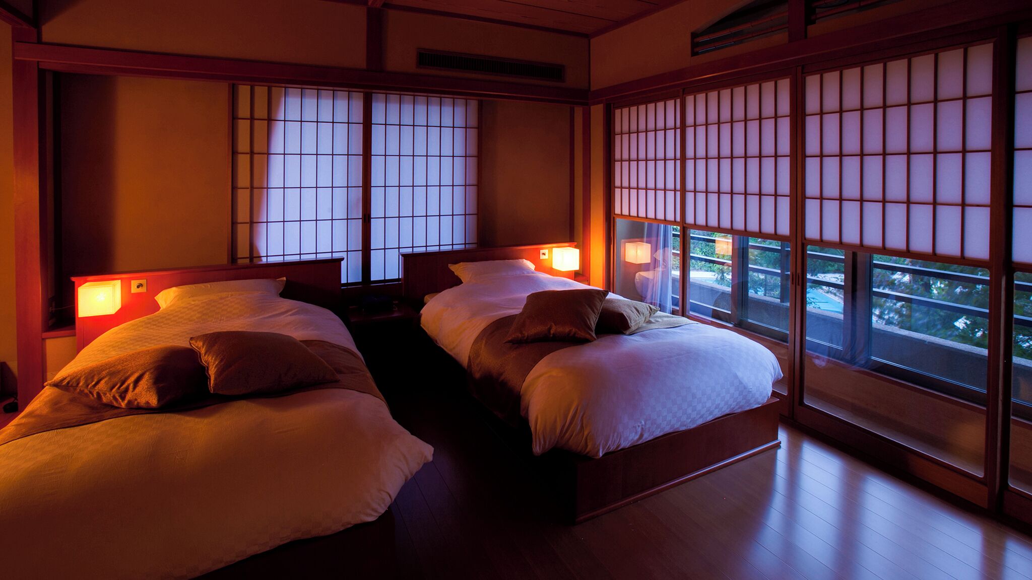 A traditional Japanese-style room with tatami flooring, sliding shoji doors, and a view of a garden.