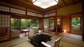 A traditional Japanese-style room with tatami flooring, a low table, and chairs. - Inn Seiryuso (Shimoda)