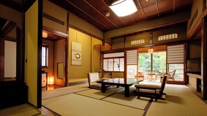 A traditional Japanese room with tatami flooring, a low table, and sliding doors. - Inn Seiryuso (Shimoda)