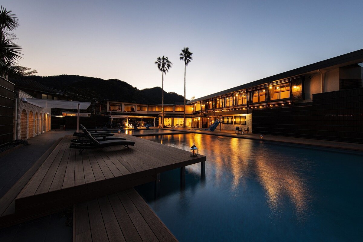 A poolside area with lounge chairs and a wooden deck.