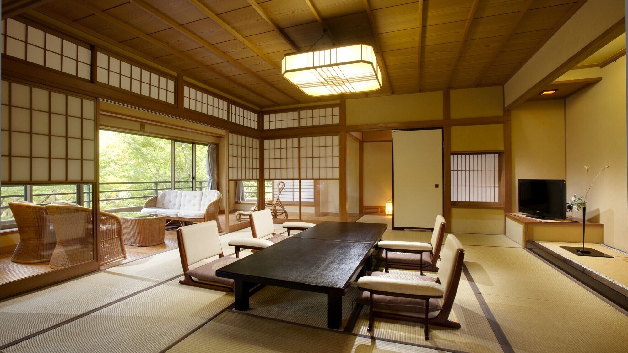 A traditional Japanese-style room with tatami flooring, a low table, and seating arrangements.