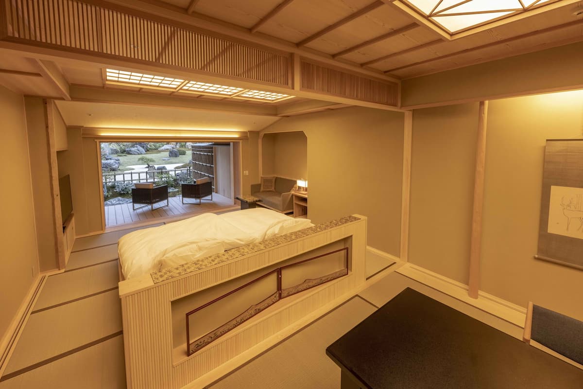 Un dormitorio con literas, un escritorio y vistas a una terraza exterior.