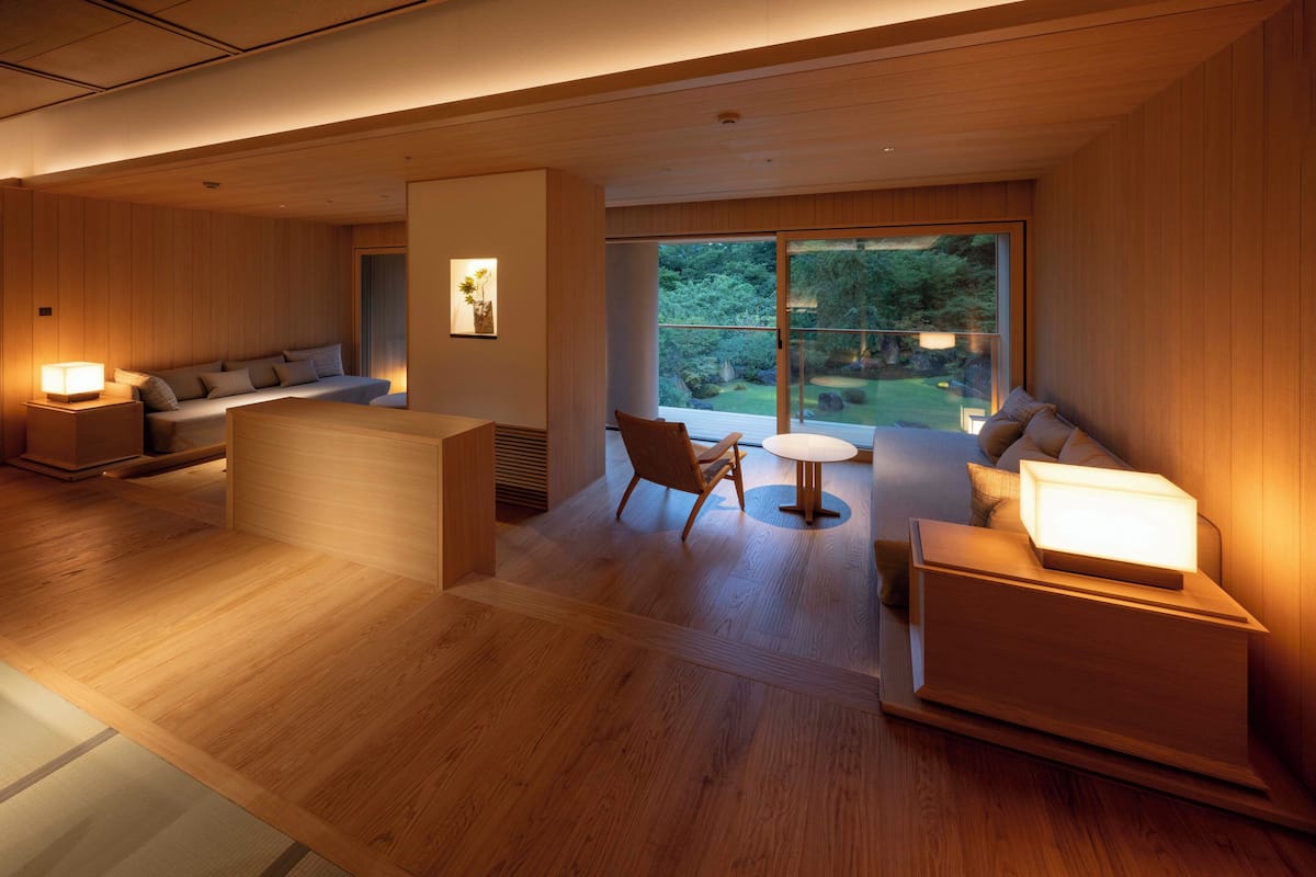Un interior moderno con suelo de madera, un sofá, una silla y una pequeña mesa.