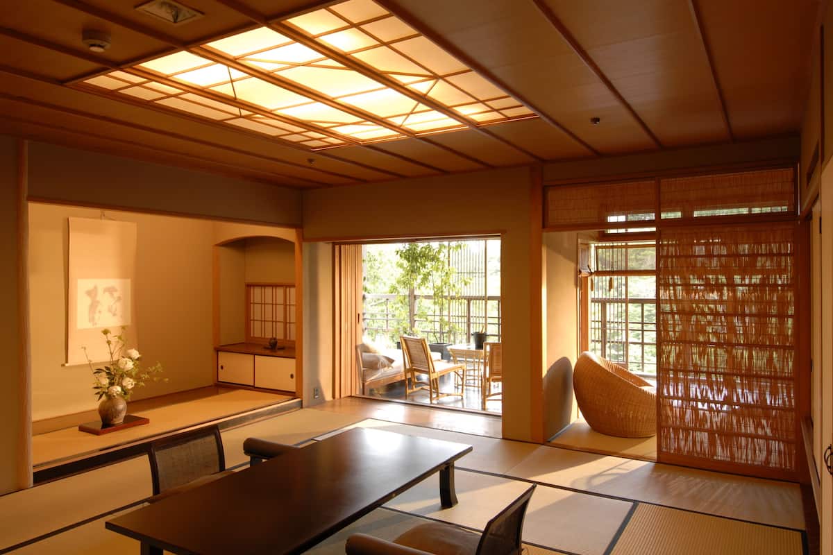 Una habitación japonesa tradicional con suelo de tatami, una mesita baja y una puerta corredera.