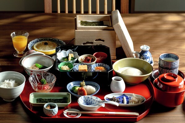 Un repas japonais traditionnel, composé de différents plats et présenté avec les ustensiles appropriés sur un plateau.