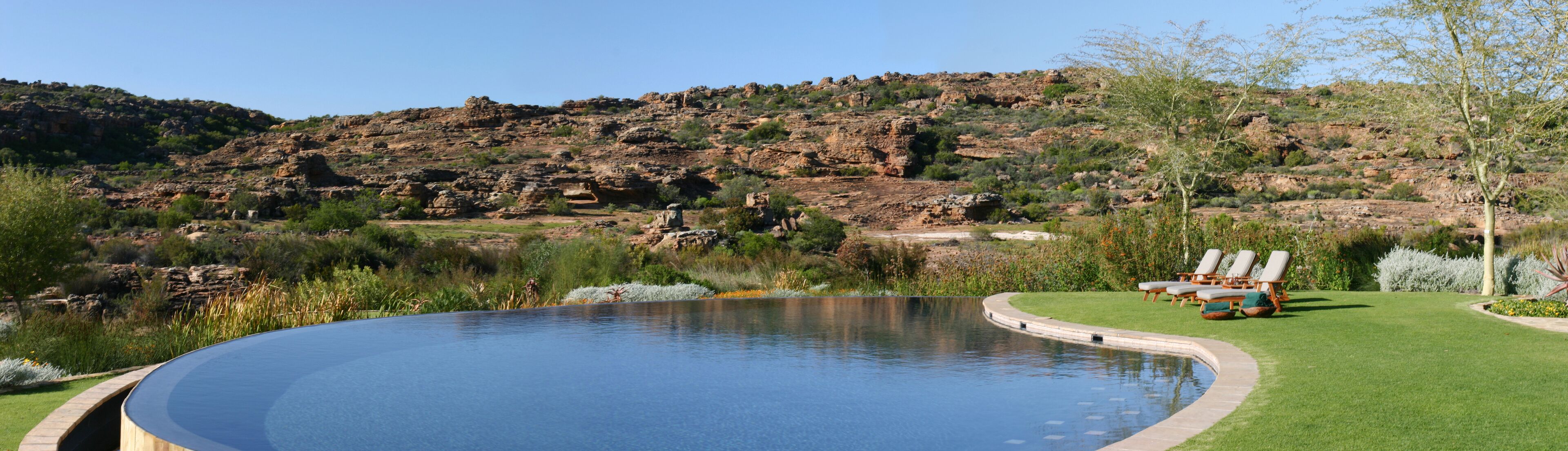 3 buitenzwembaden, ligstoelen bij het zwembad