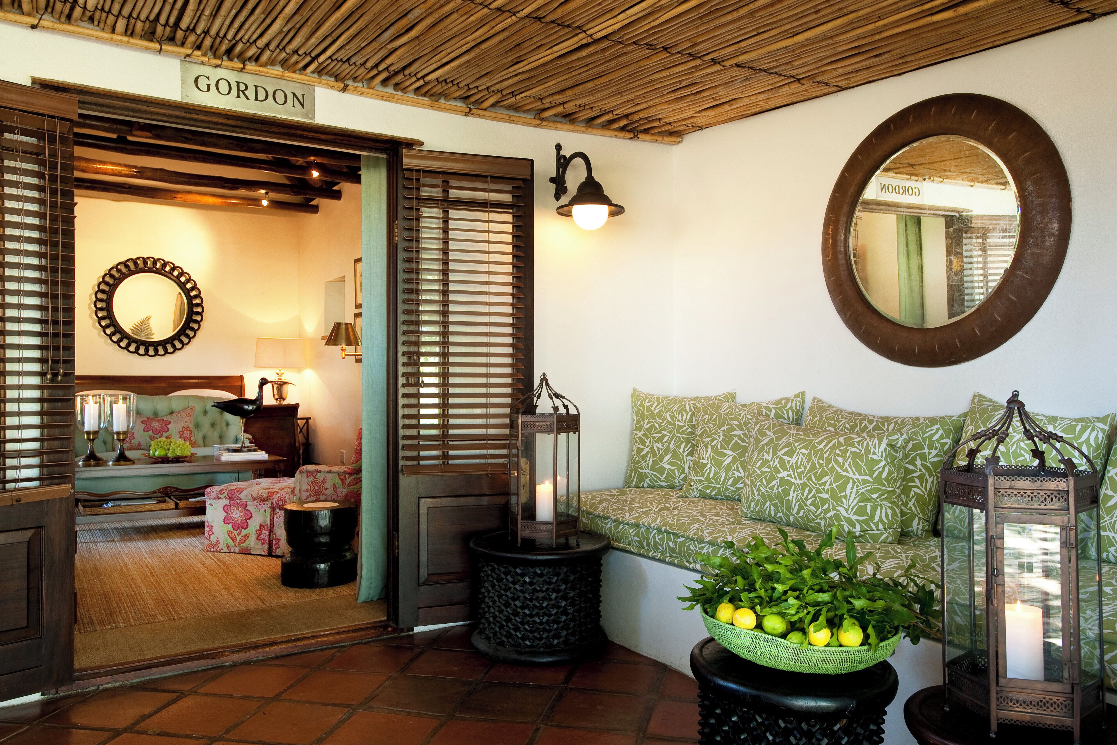 A cozy interior with a wicker bench, a mirror, and a wicker basket with lemons.