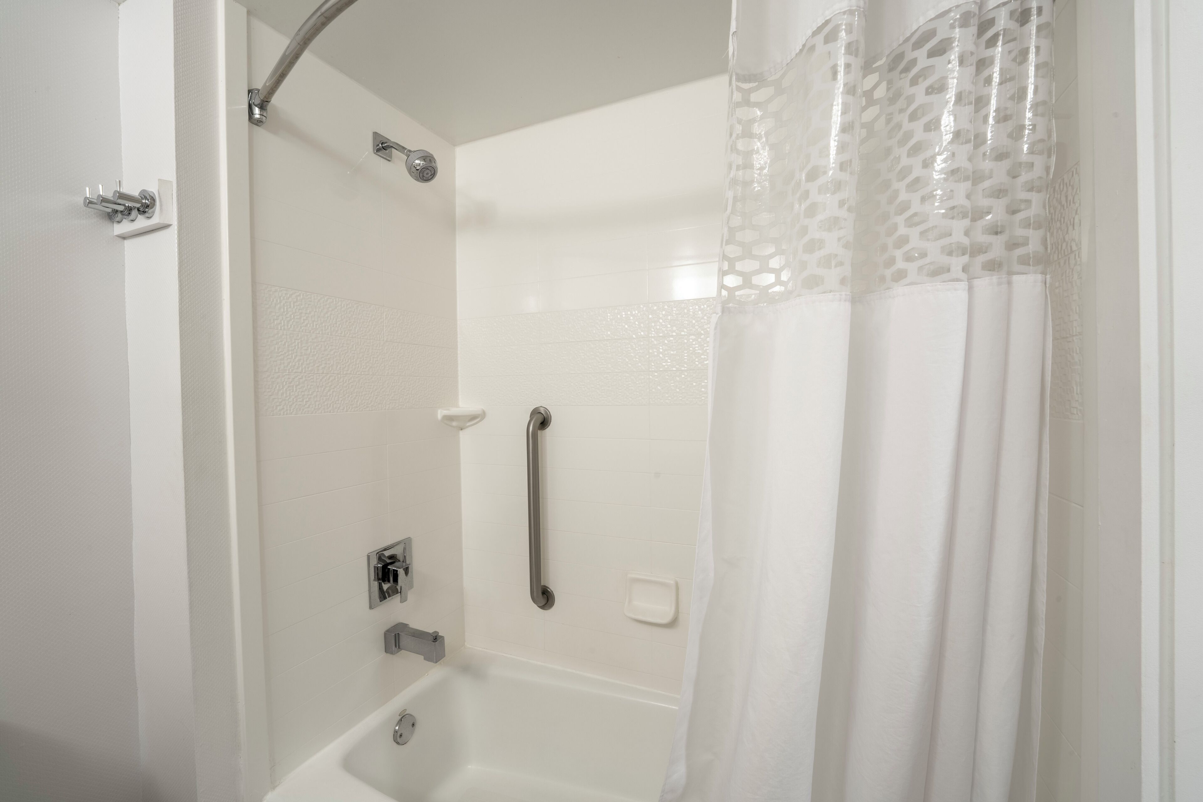 Une douche équipée d’un pommeau de douche à main, d’un système de contrôle à main pour la douche et d’un pommeau de douche à main.