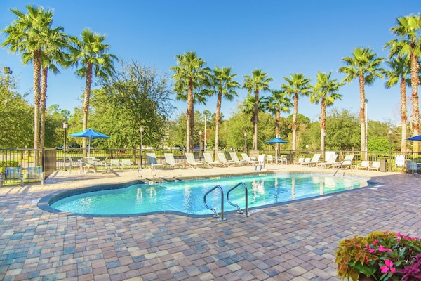 Una piscina al aire libre, sillones reclinables de piscina