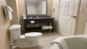 Ein Badezimmer mit Toilette, Waschbecken, Spiegel und Badewanne.