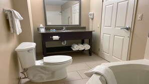 A bathroom with a toilet, sink, mirror, and bathtub. - Holiday Inn Express Bloomington West by IHG (Bloomington)